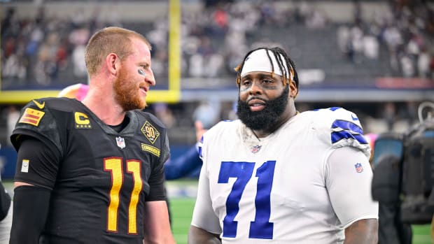 Commanders quarterback Carson Wentz (11) talks with Cowboys offensive tackle Jason Peters (71).